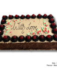 A rectangular black forest cake with chocolate frosting, decorated with piped dark chocolate rosettes topped with red cherries around the border, and red and green floral decorations with the words 'With love' written in the center. A size and flavor label is visible in the bottom right corner.