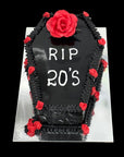 Cake designed like a tombstone with 'RIP 20's' text and red roses on a black background