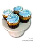 Four vanilla cupcakes with blue and white icing on a white stand.