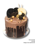 Chocolate drip cake with chocolate swirls and balls on a white background