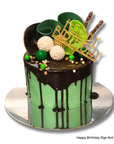 Green cake with chocolate drizzle and green and chocolate decorations on a white background