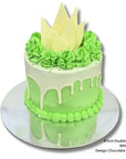 Green cake with white drip and decorative elements on a white background