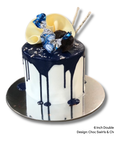 Cake with black and white frosting, blue accents, and decorative elements on a white background.