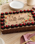 Large Black Forest cake with cherries and message on top for special event