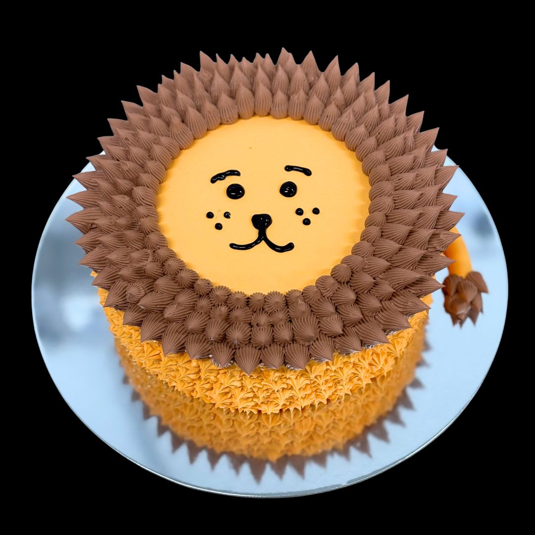Cake designed like a lion with brown mane and yellow body on a white plate. Gold Coast Birthday Cakes