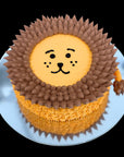 Cake designed like a lion with brown mane and yellow body on a white plate. Gold Coast Birthday Cakes