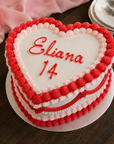 Double height love heart cake for 14th birthday with pink and red vintage piping