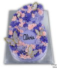 Number 6 cake with purple and pink flowers and butterflies, personalised with 'Olivia'.