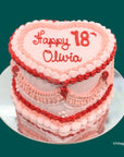 Pink and red birthday cake with 'Happy 18 Olivia' heart shaped cake with retro piping