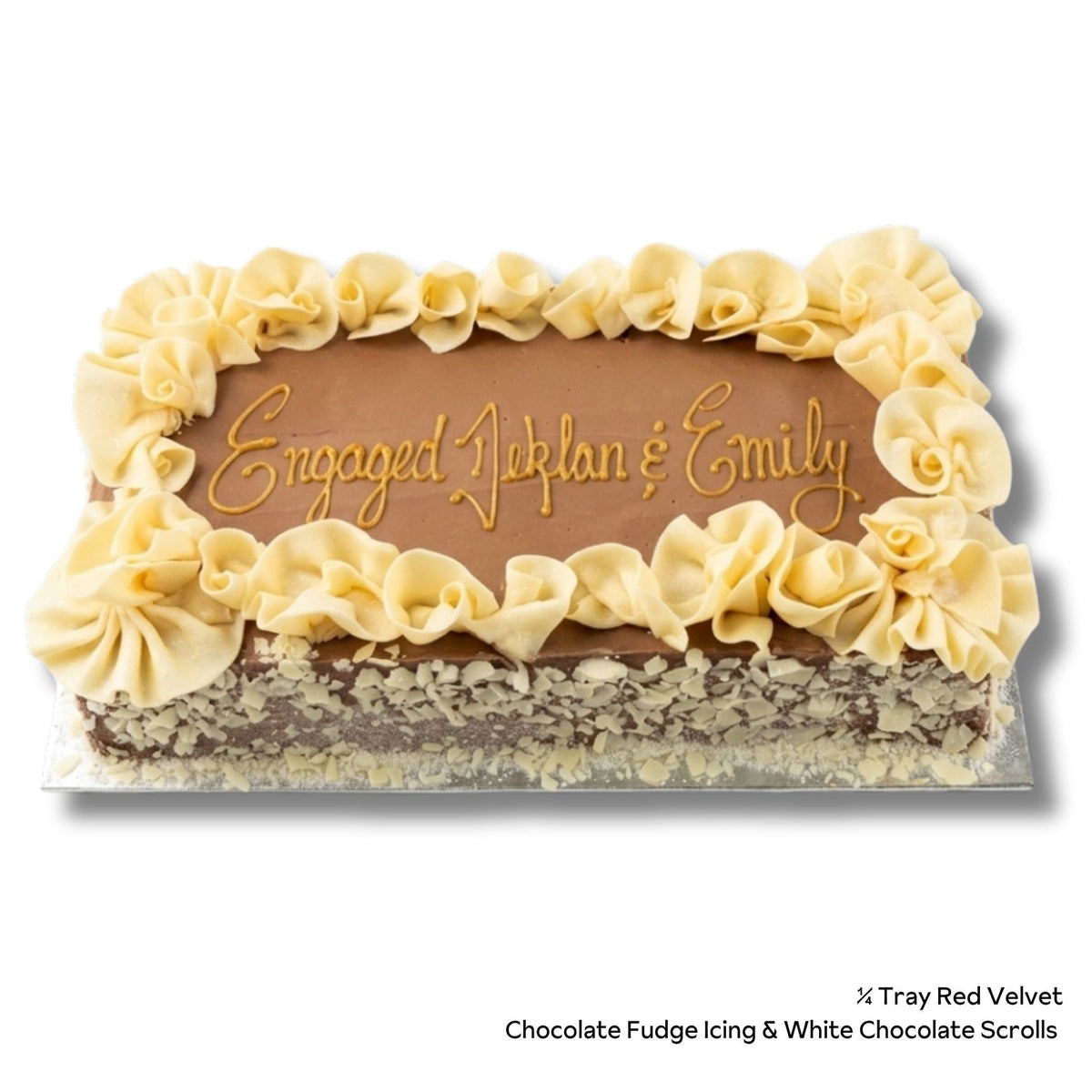 A rectangular red velvet cake with a brown chocolate base, white chocolate decorations around the border. The top is written with gold icing that reads 'Engaged: Johlan &amp; Emily'.
