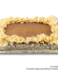 A rectangular red velvet cake with a brown chocolate base, white chocolate decorations around the border. The top is written with gold icing that reads 'Engaged: Johlan & Emily'.