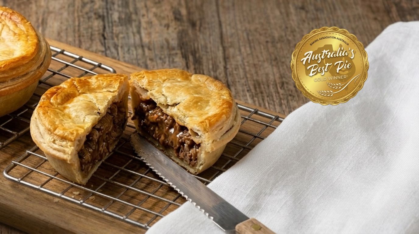 Meat  pie on a wooden board with a knife, on a wooden surface, featuring 'Australia's Best Pie' logo.