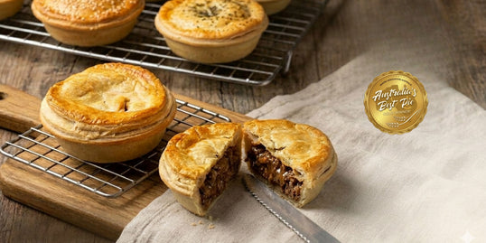 Meat  pie on a wooden board with a knife, on a wooden surface, featuring 'Australia's Best Pie' logo.