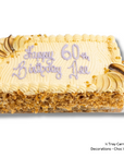 A rectangular carrot cake with cream-colored frosting, piped borders, chocolate-chip decorations, and purple icing text reading 'Happy 60th Birthday Ace.' The cake sits on a white background with a small text note in the lower right indicating carrot cake and choc wedges.