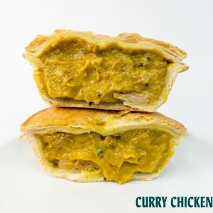 Two halves of a curry chicken pie stacked on top of each other, showing a thick yellow-orange curry filling with visible green herbs, on a white background with the text 'CURRY CHICKEN' in the bottom right corner.