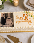 Egg & diary free large cake for anniversary with white icing and piped flowers and edible image on top. 