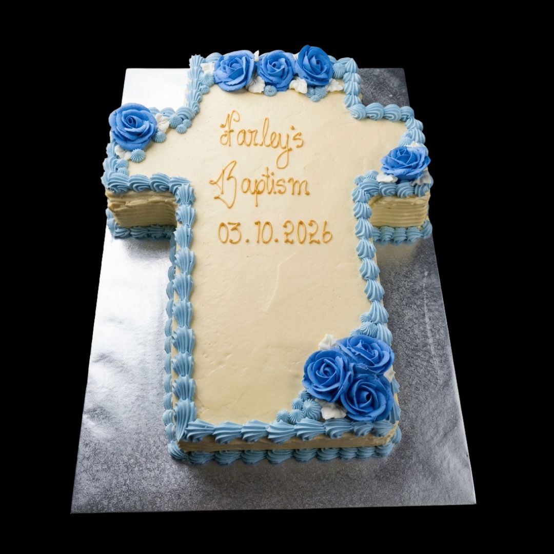 Large cross shaped cake made from carrot cake and cream cheese frosting with piped blue flowers and decorations. 