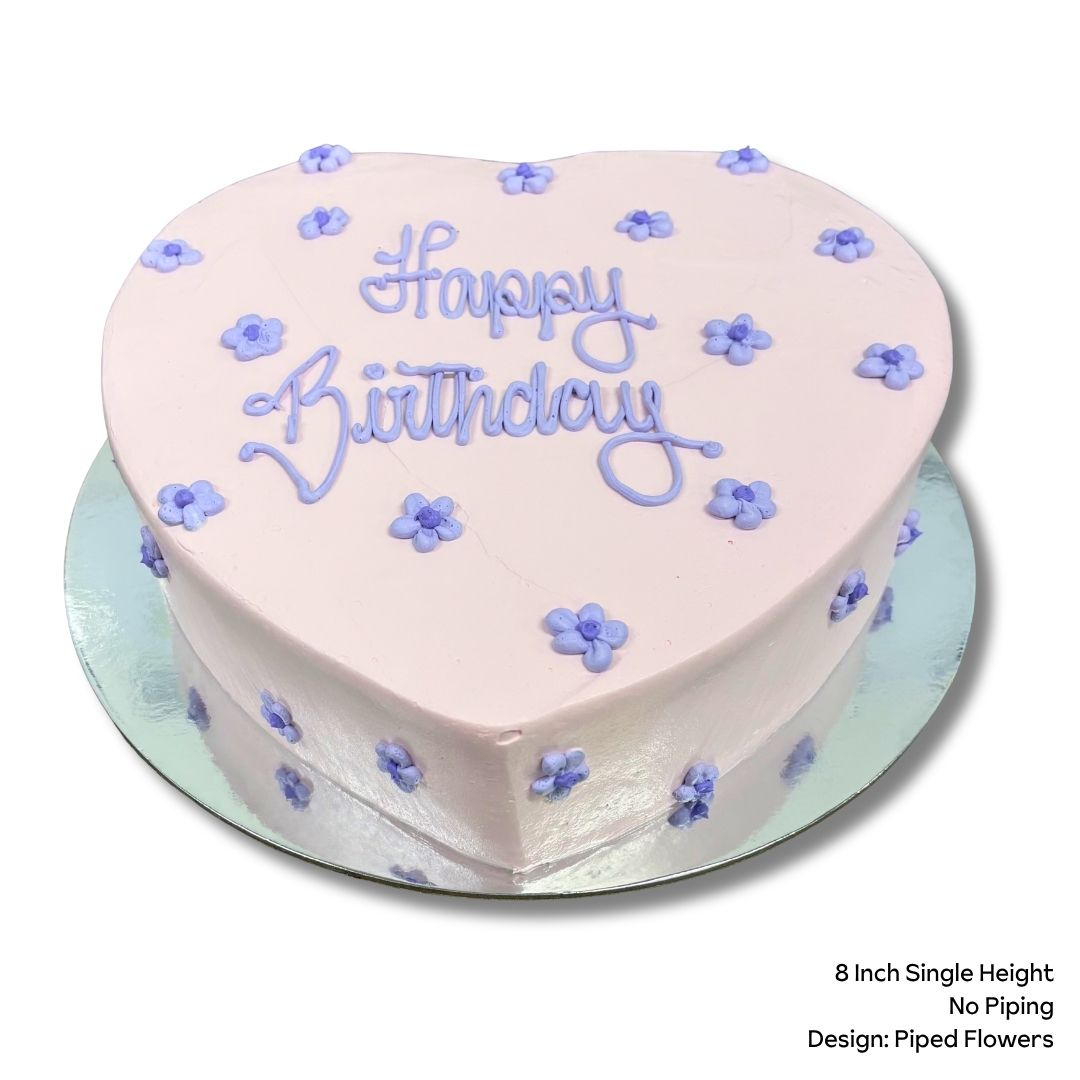 Love heart cake with purple piped flowers and birthday message