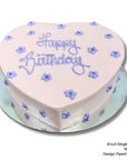 Love heart cake with purple piped flowers and birthday message