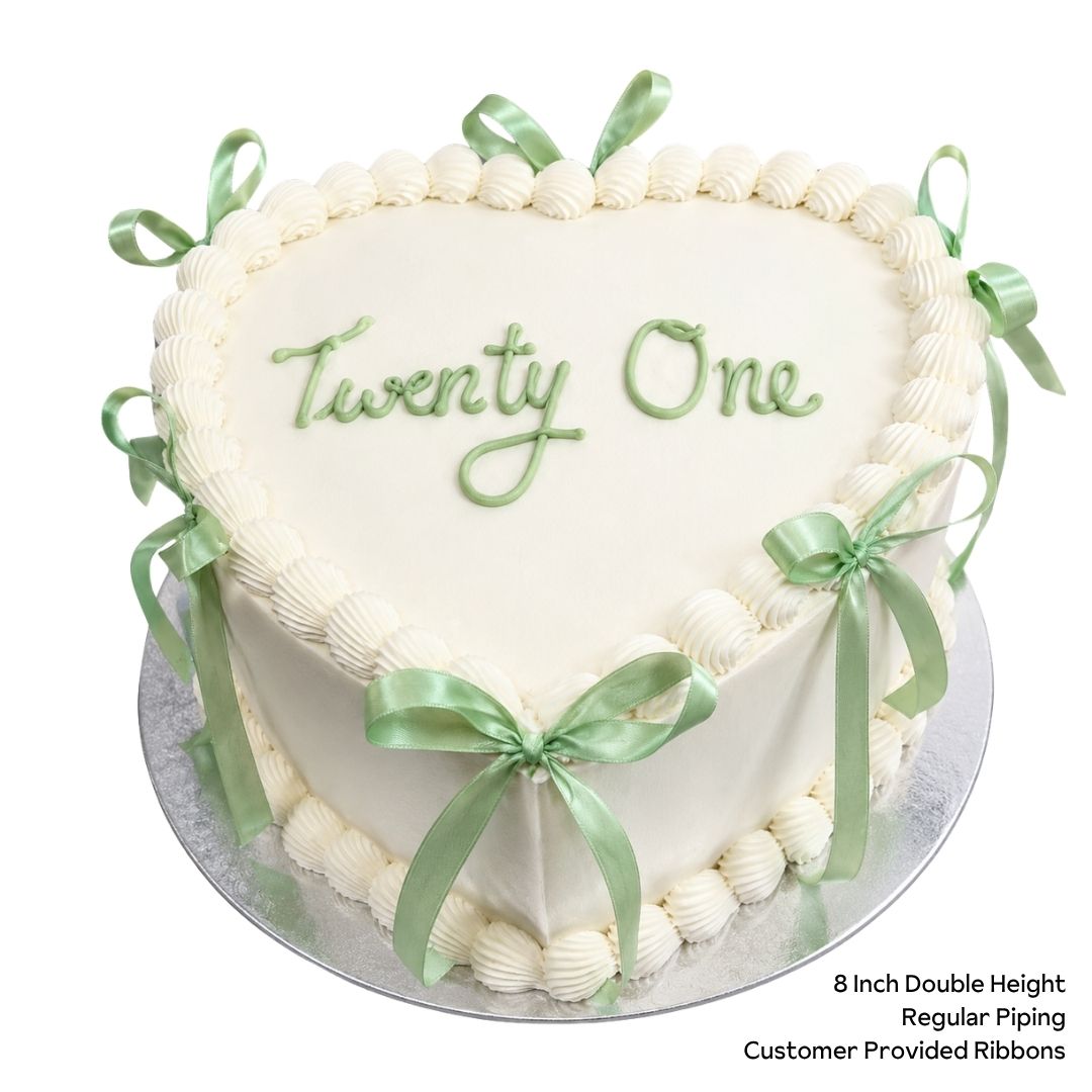 White double height love heart cake with green ribbons and birthday message
