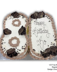 Number 80 shaped birthday cake with white icing, brown decorations, and 'Happy Birthday' text on a white background.