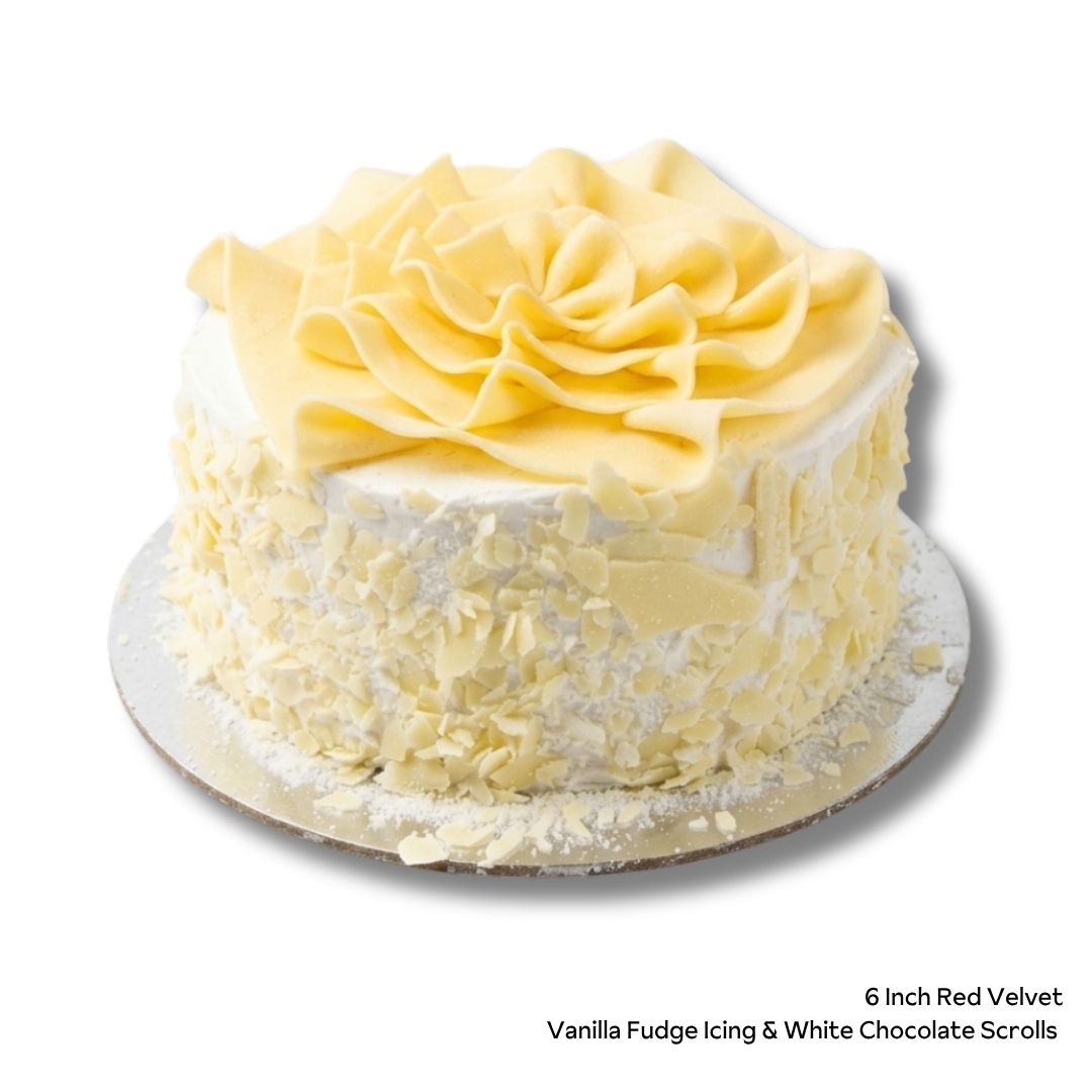 Red Velvet Birthday Cake with white icing and white chocolate scrolls