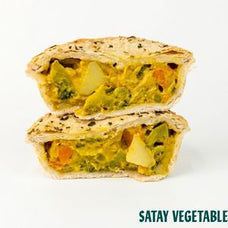 Two halves of a satay vegetable pie stacked vertically on a white background, showing a filling of mixed vegetables and a golden-brown pastry crust with black sesame seeds. The text 'SATAY VEGETABLE' is visible in the bottom right corner.